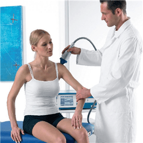 Lékař provádí léčbu osteochondrosy u ženy